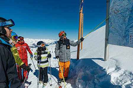 Neilson Mountain Expert explaining a piste map to a group of skiers